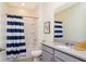 Bathroom with shower/tub combo, gray vanity, and blue striped curtain at 2182 Fleming Mist Pl, Kissimmee, FL 34747