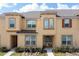 Tan two-story townhome with brown door and landscaping at 2182 Fleming Mist Pl, Kissimmee, FL 34747