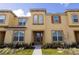 Tan three-story townhome with front door and landscaping at 2182 Fleming Mist Pl, Kissimmee, FL 34747