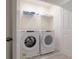 Bright laundry room with Whirlpool washer and dryer, and overhead shelving at 2182 Fleming Mist Pl, Kissimmee, FL 34747