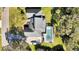 Birds eye view of the home and screened in pool, surrounded by mature landscaping at 2305 Leeward Cv, Kissimmee, FL 34746