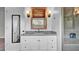 Bathroom vanity features granite counters, wood-trimmed mirror, and decorative sconces at 2305 Leeward Cv, Kissimmee, FL 34746