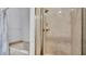 Featuring a combined tub/shower with glass door and marble tile at 2305 Leeward Cv, Kissimmee, FL 34746