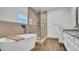 Modern bathroom featuring a soaking tub, glass shower, and neutral colored tiles at 2305 Leeward Cv, Kissimmee, FL 34746