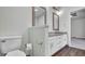 Bathroom features a toilet, tiled floor, and vanity with granite countertop and double mirrors at 2305 Leeward Cv, Kissimmee, FL 34746