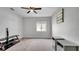 A carpeted bedroom with neutral paint, ceiling fan, window, TV stand, and two grey nightstands at 2305 Leeward Cv, Kissimmee, FL 34746
