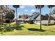 Sprawling backyard with lush greenery, featuring a screened-in pool and covered patio at 2305 Leeward Cv, Kissimmee, FL 34746