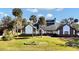 House exterior showcasing a two-story home with a spacious lawn and palm trees at 2305 Leeward Cv, Kissimmee, FL 34746