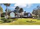 Spacious home featuring a lush lawn, mature palm trees, and unique architectural details at 2305 Leeward Cv, Kissimmee, FL 34746