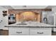 Close up of kitchen island and brick oven area, stainless refrigerator, and light colored cabinets at 2305 Leeward Cv, Kissimmee, FL 34746