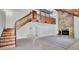 Spacious living room showing stairs, balcony, stone fireplace, and wood ceiling at 2305 Leeward Cv, Kissimmee, FL 34746