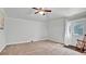 Neutral colored living room with ceiling fan, door to backyard, and neutral carpeted floors at 2305 Leeward Cv, Kissimmee, FL 34746