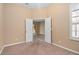 Bright bedroom with neutral walls, carpet flooring, and access to another room at 24728 Calusa Blvd, Eustis, FL 32736