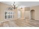 Bright dining room with hardwood floors and chandelier; view of kitchen at 24728 Calusa Blvd, Eustis, FL 32736