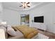 Main bedroom with sliding doors to the pool area, ceiling fan and tv at 24728 Calusa Blvd, Eustis, FL 32736