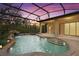 Relaxing screened pool and spa with waterfall feature at sunset at 24728 Calusa Blvd, Eustis, FL 32736