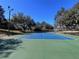 Well-maintained tennis court with surrounding greenery at 24728 Calusa Blvd, Eustis, FL 32736