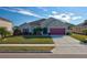 Single-story house with a gray exterior, pink garage door, and well-manicured lawn at 2518 Hayden Valley St, Apopka, FL 32703