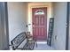 Welcoming front entry with a burgundy door, bench, and decorative welcome sign at 2518 Hayden Valley St, Apopka, FL 32703