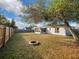 Large backyard with a fire pit, wooden fence, and a large tree providing shade at 255 Autumn Ridge Rd, Deltona, FL 32725