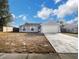 Front view of a gray house with a white garage door and a spacious lawn at 255 Autumn Ridge Rd, Deltona, FL 32725