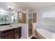 Well-lit bathroom featuring a glass shower, soaking tub, double sink, and neutral paint at 2570 Marshfield Preserve Way, Kissimmee, FL 34746