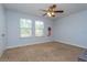 Spacious carpeted bedroom featuring two windows, a ceiling fan, and light blue painted walls at 2570 Marshfield Preserve Way, Kissimmee, FL 34746