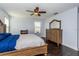 Bedroom with a wood bed frame, hardwood floors, dresser, and natural light from a window at 2570 Marshfield Preserve Way, Kissimmee, FL 34746