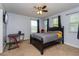 Bedroom with a black bed frame, ceiling fan, and two windows with natural light at 2570 Marshfield Preserve Way, Kissimmee, FL 34746