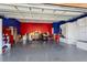 Spacious garage with high ceilings, epoxy flooring, storage, and vibrant red and blue accent walls at 2570 Marshfield Preserve Way, Kissimmee, FL 34746