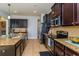 Kitchen with stainless steel appliances, granite counters, and dark wood cabinets at 2570 Marshfield Preserve Way, Kissimmee, FL 34746