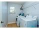 Efficient laundry room featuring a washer, dryer, storage shelf, and natural light from a nearby window at 2570 Marshfield Preserve Way, Kissimmee, FL 34746