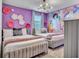 Bright bedroom featuring two twin beds with purple accents and princess wall art at 3012 Penelope Loop, Kissimmee, FL 34746