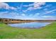 Scenic view of a calm lake with lush green shoreline and a clear blue sky at 3012 Penelope Loop, Kissimmee, FL 34746