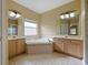 Bright bathroom featuring dual vanities, a soaking tub, and tile flooring at 337 Fern Lake Dr, Orlando, FL 32825