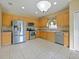 Bright kitchen features stainless steel appliances, light wood cabinets, and tile flooring at 337 Fern Lake Dr, Orlando, FL 32825