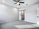 Bright bedroom with grey carpet and barn door leading to bathroom at 413 Ruby Ave, Deland, FL 32724