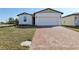 Charming single-story home featuring a brick driveway, manicured lawn, and a two-car garage at 4537 Sidesaddle Trl, St Cloud, FL 34772