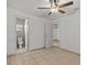 Spacious bedroom with tile floors, ceiling fan, and access to bathroom at 7852 Murcott Cir, Orlando, FL 32835