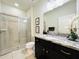 Bathroom with granite countertop, dark vanity, and shower at 8902 Sydney Ave, Kissimmee, FL 34747