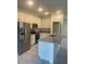 Modern kitchen with white cabinets, granite island, and stainless steel appliances at 8944 Sw 128Th Pl, Ocala, FL 34473