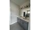 Double vanity bathroom with gray cabinets and a large mirror at 922 Umbria Dr, Poinciana, FL 34759