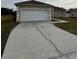 White garage door with cracked driveway at 975 Gascony Ct, Kissimmee, FL 34759