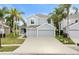 Two-story house with gray siding, three-car garage, and palm trees at 9856 Heron Pointe Dr, Orlando, FL 32832