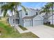 Two-story house with gray siding, three-car garage, and palm trees at 9856 Heron Pointe Dr, Orlando, FL 32832