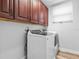 Laundry room with modern washer and dryer, and wood cabinets at 9856 Heron Pointe Dr, Orlando, FL 32832