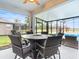 Covered patio with fire pit table and wicker furniture, overlooking the pool at 9856 Heron Pointe Dr, Orlando, FL 32832