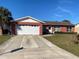 Front view of a red brick house with a white garage door at 102 San Blas Ave, Kissimmee, FL 34743