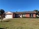 Brick house with a two-car garage and a well-maintained lawn at 102 San Blas Ave, Kissimmee, FL 34743