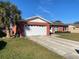 Front view of a red brick house with a white garage door at 102 San Blas Ave, Kissimmee, FL 34743